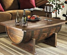 a wooden table with wine glasses and fruit on it in front of a brown couch