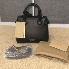 Burberry Baby Banner Black Leather Handbag Brand New, Tags Attached, Dust Bag Included, Care Cards Included, Shoulder Strap Included Designer: Burberry Article Number: 8036492 Style: Tote/Shoulder Bag Condition: New With Tags And Dust Bag Measurements: 10.5” Long, 8” High, 4.5” Deep Size: Small/ “Baby Banner” Material: Leather Color: Black Hardware Color: Polished Gold-Tone Msrp Us $1150 Banner Material, Burberry Baby, Banner Black, Burberry Tote, Black Leather Handbag, Baby Banners, Black Handbag, Bag Measurements, Small Baby