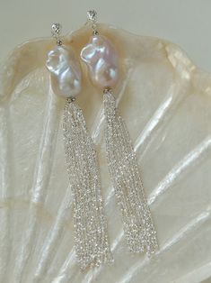 Unleash the allure of individuality with these one-of-a-kind, large natural Baroque pearls. Paired with the sparkling brilliance of Italian-crafted 925 silver lotus chain tassels, these earrings exude a captivating blend of glamour and sophistication. Metal: Recycled Sterling Silver Gemstone: Freshwater Baroque Pearl Earring Dimensions: 11.5cm Weight: 10g Elegant Dangle Earrings With Silver Chain, Elegant Silver Chain Dangle Earrings, Elegant Long Drop Jewelry For Celebrations, Luxury Silver Earrings With Pearl Chain, Silver Earrings With Pearl Chain For Evening, Silver Pearl Chain Earrings For Evening, Silver Long Drop Pearl Earrings With Dangling Beads, Silver Party Pearl Earrings With Pearl Chain, Luxury Silver Pearl Chain Earrings