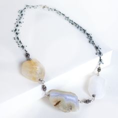 The Trio Necklace features a combination of Agate, Citrine, and rainbow moonstone pendants on a delicate Aquamarine chain. This unique piece is sure to add a touch of fun to any outfit. Length: 18" All Sterling Silver White Gemstone Fusion Necklace, Fusion Style White Gemstone Necklace, Bohemian Chalcedony Natural Stone Necklaces, Bohemian Chalcedony Natural Stone Necklace, Bohemian Chalcedony Necklace With Natural Stones, Trio Necklace, Moonstone Pendant Necklace, Rainbow Moonstone Pendant, Moonstone Pendant