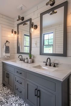 a bathroom with two sinks, mirrors and lights on the wall next to each other