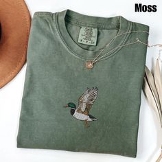 Embroidered Duck Comfort Colors Shirt | Animal Lover Shirt | Embroidery Shirt | Embroidered Gift | Duck Shirt Matching Sweatshirt: https://printworkshopcompany.etsy.com/listing/1767779984/embroidered-duck-sweatshirt-animal-lover ** VIP Email List Be sure to join our VIP Email list for new product releases, special promotions, and giveaways! https://email.everbee.io/subscribe?shopName=PrintWorkshopCompany ** HOW TO ORDER 1. Check our photos for sizing and color options. 2. Select your size and color from the drop-down menus. 3. Click "ADD TO CART" to add the shirt to your cart. 4. Click "PROCEED TO CHECKOUT" to purchase your shirt. ** DETAILS: The garment-dyed t-shirt by Comfort Colors is a customizable tee made entirely from 100% ring-spun cotton. ** SIZING : - Please refer to size chart o Fall Embroidered Crew Neck Shirt, Embroidered Crew Neck Shirt For Fall, Embroidered Green Cotton Shirt, Green Embroidered Cotton Shirt, Green Cotton Tops With Machine Embroidery, Cotton Tonal Embroidery Short Sleeve Tops, Cotton Tops With Tonal Embroidery And Short Sleeves, Duck Sweatshirt, Embroidered Duck