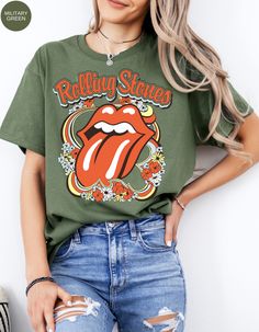 Step back in time and rock out in style with our Vintage Flower Rolling Stone Tee! 🌸🎸 This retro-inspired t-shirt features a classic Rolling Stone logo beautifully intertwined with vibrant flowers, capturing the free-spirited essence of rock 'n' roll and the timeless charm of the 70s. 🌼✨ Crafted from super-soft, high-quality fabric, this tee offers ultimate comfort and a perfect fit, making it an essential addition to your wardrobe. Whether you're heading to a concert, a festival, or just channeling your inner rock star, this tee will have you looking effortlessly cool and totally groovy. 🌟👕 Get ready to roll and bloom with style! 🌿🎶🛒 Retro Green Printed T-shirt, Retro Relaxed Fit T-shirt For Music Festival, Casual Fall T-shirt With Vintage Print, Casual Vintage Print T-shirt For Fall, Vintage Concert T-shirt For Fall, Vintage Fall Concert T-shirt, Groovy Summer T-shirt With Letter Print, Retro Short Sleeve T-shirt With Floral Print, Spring Hippie Retro Print T-shirt