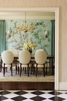 a dining room table with four chairs and a chandelier