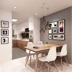 a dining room table with white chairs and pictures hanging on the wall above it in front of a kitchen