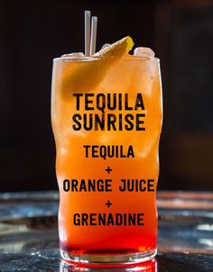 a tall glass filled with orange juice and an orange slice on top of the drink