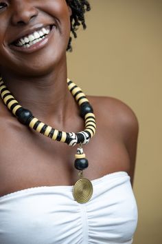 Unique Africa Maasai Handcrafted Leather Beaded Necklace with an Elegant Look and Brilliant Finish. Color = Black, Cream, and White with a brass pendant. Length (Around Neck) =20 Inches. **GET FREE SHIPPING FOR ADDITIONAL ITEMS PURCHASED. Yes, Buy Multiple Items and pay shipping for 1 item only- The rest ships Free. (No Limits on the number of Multiple items). With a faster delivery time of 3 days via DHLExpress, Worldwide. Ordinary/Standard Shipping also available upon request. We Custom Make t Black Artisan Round Necklace, Artisan Black Round Necklace, Gift Black Choker With Large Beads, Black Wooden Beads Necklace For Jewelry Making, Unique Black Wooden Beads Jewelry, Handmade Black Beaded Necklace With Round Pendant, Artisan Black Choker As A Gift, Black Artisan Choker For Gift, Artisan Black Choker For Gift