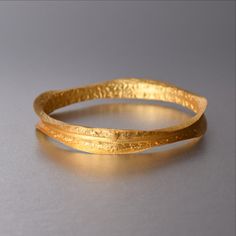 Elia Bracelet In Gold Gold Bangle With Oyster Bracelet For Anniversary, Elegant Gold Brass Cuff Bracelet, Gold-tone Brass Bangle, Elegant Yellow Gold Brass Cuff Bracelet, Gold Plated Bangle For Formal Occasions, Formal Bangle Bracelets With Plating, Gold Brass Jubilee Bangle, Formal Plated Bangle Bracelets, Gold Stackable Bracelets For Parties