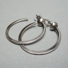 "Silver hoop earrings, I hammered the hoop of wire, then I soldered it to a half silver granule, and to the back, I soldered a pin. They are light, with a simple and clear design, suitable to be worn on many occasions weight 0.10 oz length 1.18\" width1.18\" Simple jewel, but made original by craftsmanship, which adds value and features to each of my pieces. Thank you for visiting my shop, if you like to receive news and updates please save me in your favs you can find me on Instagram; @Petrahje Silver Hand Forged Hoop Earrings, Silver Hand Forged Small Hoop Earrings, Hand Forged Small Hoop Silver Earrings, Sterling Silver Soldered Hoop Earrings, Hand Forged Silver Hoop Earrings, Hoop Earrings Handmade, Hammered Hoop Earrings, Sterling Silver Hoop Earrings, Sterling Silver Hoops