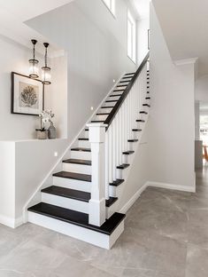 a staircase with black and white steps leading up to the second floor in a house