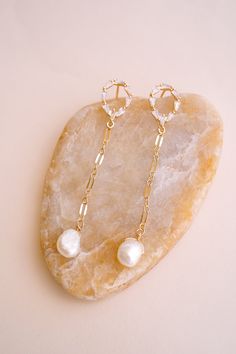 Add a touch of classic, yet glam style with our Gwen Pearl Drop Earrings! These delicate dangle earrings feature an elegant and minimalist design that effortlessly elevates your look! Adorned with freshwater pearls, they're sure to make you stand out. FEATURES Materials: 14K Gold Filled Chain, Pavé Cubic Zirconia, Freshwater Pearls Dimensions: 2.5" drop Everyday Luxury White Pearl Drop Jewelry, Timeless Pearl Charm Drop Earrings, Pearl Drop Linear Earrings, Delicate Pearl Drop Dangle Earrings, Luxury Long Drop Pearl Earrings For Wedding, Delicate Pearl Charm Dangle Earrings, Delicate Pearl Charm Drop Chandelier Earrings, Luxury Dangle Pearl Earrings, Elegant Pearl Charm Chandelier Dangle Earrings