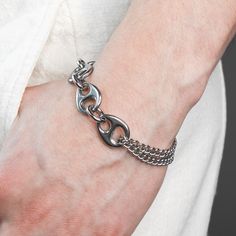 DESCRIPTION: This Pluto bracelet is robust yet comfy. It is made of tarnish resistant stainless steel and finished with a swivel lobster clasp closure. Unique polished liquid like links and a looped rounded curb chain come together with thoughtful construction. Available in four sizes, this bracelet is made just for you. DETAILS: available in 4 sizes 1.5 adjustable tail chain Rhodium plated Hematite stone stainless steel grunge aesthetic modern futuristic unisex FIT: Model has a 7 inch wrist and Modern Metal Cuban Link Chain Bracelet, Modern Metal Bracelets With Curb Chain, Modern Stainless Steel Cuban Link Bracelet With Adjustable Chain, Modern Stainless Steel Cuban Link Chain Bracelet, Modern Cuban Link Metal Bracelet, Trendy Metal Chain Bracelet With Curb Chain, Adjustable Cuban Link Bracelet With Stainless Steel Clasp, Stainless Steel Chain Bracelet With Solid Links, Trendy Stainless Steel Link Chain Bracelet