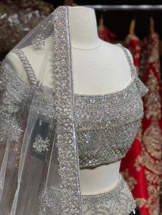 Iced cube sliver lehenga with frosted crystal embroidery teamed with a spaghetti strap blouse with crystal embroidery and net dupatta. Fabric: Net Custom designed according to client measurements and color preference. Production and delivery time is 120 days! Sliver Lehenga, Chaniya Choli For Sangeet, Designer Silver Organza Lehenga, Silver Hand Embellished Sharara For Wedding, Silver Party Wear Sets With Intricate Embroidery, Silver Embellished Organza Lehenga, Embellished Silver Organza Lehenga, Designer Embellished Silver Lehenga, Silver Hand Embellished Lehenga For Wedding