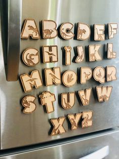 wooden letters and numbers are placed on the side of a stainless steel refrigerator freezer