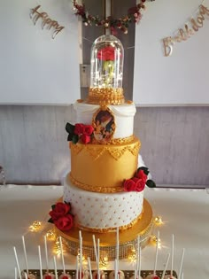 a three tiered cake sitting on top of a table covered in lots of candy