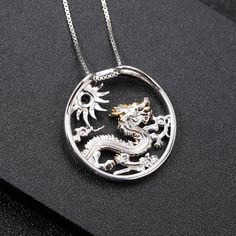 "Embark on a journey of mythical elegance with our sterling silver and gold necklace, featuring the majestic Chinese zodiac dragon alongside a radiant sun centerpiece adorned with your choice of blue topaz, diopside, or opal gemstones. 🐉🌞✨ This enchanting piece blends ancient symbolism with modern sophistication, capturing the essence of strength, power, and celestial beauty. Meticulously crafted with intricate detailing, the dragon symbolizes courage and wisdom, while the sun represents vital Spiritual Gold Jewelry With Dragon Design, Symbolic Gold Jewelry With Dragon Design, Symbolic Gold Dragon Jewelry, Celestial Round Pendant Jewelry With Hallmark, Gold Jewelry With Dragon Design, Yellow Gold Dragon Pendant Jewelry, Gold Round Jewelry With Dragon Design, Yellow Gold Dragon Design Pendant Jewelry, Gold Dragon Design Jewelry