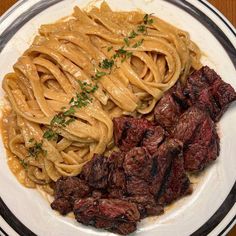 a plate with steak, noodles and sauce on it