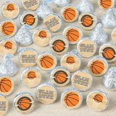 basketball themed cupcake toppers with foil wrappers on a wooden table in front of them