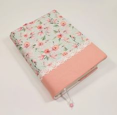 a pink and white flowered notebook with lace