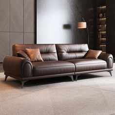 a brown leather couch sitting in a living room next to a lamp