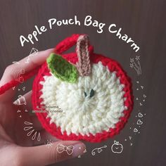 a crocheted apple pouch bag charm in red and white with a green leaf on top