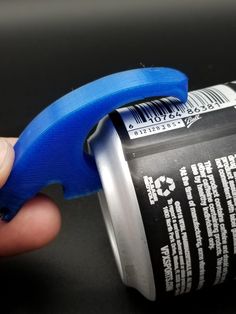 a hand holding a can of soda with a blue handle