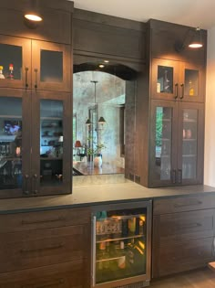 a kitchen with wooden cabinets and glass doors