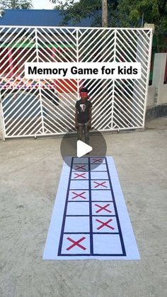 a person sitting on a chair in front of a white gate with the words memory game for kids