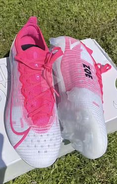 a pair of pink and white shoes sitting on top of a box