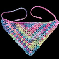 a multicolored crocheted bib on a black background