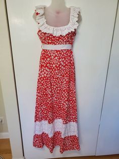 "Amazing vintage dress from the 70's! Has two designer labels.  Princess Kaiulani Hawaii and Carol & Mary Hawaii. Red floral cotton fabric. Bust has a white cotton lining. Maxi length. Floral lace accents, ruffles around collar. Sleeveless. Zips in back with eye hook. Comes with a white ribbon, I do not believe this is the original sash, but it works or you can find your own (loops attached).  Pockets. In Excellent Vintage Condition with no visible flaws! Size on tag 10. Measurements: Bust: 36\" Vintage White Sleeveless Maxi Dress, White Lined Cotton Vintage Dress, White Cotton Lined Vintage Dress, Retro White Maxi Dress For Spring, White Cotton Vintage Dress With Lining, White Cotton Lined Maxi Dress, White Cotton Vintage Summer Dress, 1970s Style White Maxi Dress, White Cotton Vintage Dress For Summer