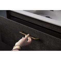 a person's hand reaching into a drawer with a handle on the front door