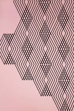 a black and white pattern on a pink wall