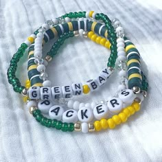 🏈 Who loves football? Who loves the Green Bay Packers? Show your team spirit with this fun bracelet set! Great for gift giving!! Lightweight and oh so comfy to wear. Available as a 3 or 4 piece set. The 4 piece set includes faceted crystals to make it super sparkly! It will also have gold accents to match the other bracelets. Each piece is handmade with: - High Quality Glass Seed Beads - Heishi Vinyl Beads - White/Black Acrylic Round and Cube Letter Beads - Faceted Rondelle Crystals (in 4 piece Cheap Beaded Stretch Bracelet For Sports Events, Team Spirit Bracelets With Letter Beads, Team Spirit Beaded Bracelets For Game Day, Game Day Bracelets With Letter And Round Beads, Team Spirit Round Beads Jewelry For Game Day, Game Day Team Spirit Stretch Bracelet With Round Beads, Personalized Beaded Bracelets For Game Day, Team Spirit Letter Beads Wristband For Game Day, Team Spirit Wristband With Letter Beads For Game Day