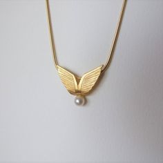 "This is a unique necklace, inspired by angel wings. It's very elegant and is great to give as a gift. It's made of 14k gold and you can choose which color 14k gold it will be made of - yellow or white gold I plate the white gold with rhodium, as is common in white gold jewelry. There is a single natural white pearl attached to the bottom of the pendant and the pendant has an elegant matte finish. The size of the pendant is 0.81 / 0.7 inches ( 2.1 / 1.8 cm ) Choose the length of the necklace you Elegant Gold Wing-shaped Jewelry, Elegant Wing-shaped Gold Jewelry, Elegant Wing-shaped Yellow Gold Necklace, Elegant Yellow Gold Wing-shaped Necklace, Elegant Angel Wings Necklaces, Angelic Gold Pendant Necklace, Elegant Gold Winged Jewelry, Elegant Winged Gold Jewelry, Elegant Angel Wings Jewelry