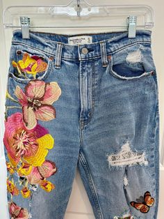 Size:  4 Embellished flowers and butterflies on A&F jeans.   It's young, hippie and retro. Floral print and lace patches underneath, it's cute and doable.  It's stylish and comfy. Embellished Flowers, Denim Upcycle, Hippie Jeans, Altered Clothing, Unique Skirts, Long Necklace Boho, White Denim Skirt, Butterfly Embroidery, Flowers And Butterflies