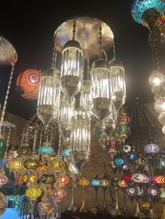 a chandelier with many different colored lights hanging from it's sides and on the ceiling