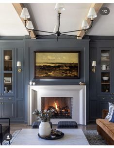 a living room filled with furniture and a fire place next to a painting on the wall