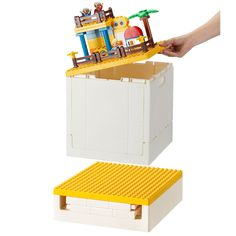 a lego boat with people on it is being held over by someone's hand