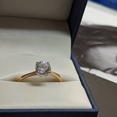 an engagement ring in a box on a table