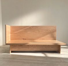 a wooden bench sitting on top of a cement floor