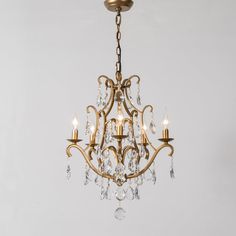 a gold chandelier with crystal drops hanging from it