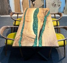 a table made out of wood with green paint on the top and bottom, sitting in front of two chairs