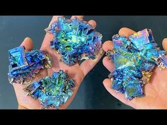 two hands holding blue and green crystals