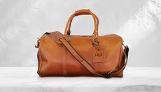 "Personalized Leather Duffle Bag - Custom Travel Weekend Bag - Handcrafted Luxury DETAILS - %100 Cowhide Leather - Best Zipper Brand of YKK Used in The Bags  - Handmade COLORS - Black  - Dark Brown - Light Brown SIZES - Small Size: 14\" - 10 - 10\" inches - X-Large Size: 21\" - 11\" - 11\" inches PERSONALIZATION We can engrave initials, name and logo to the luggage tag attach to the bag. We just have letters A - Z a-z, numbers 0-9 and characters: & and ❤️ Initials: Max. 4 Characters Names: Max. Brown Leather Bags With Engraved Logo, Classic Brown Bag With Engraved Logo, Classic Brown Bags With Engraved Logo, Brown Travel Bags With Engraved Logo, Brown Bags With Engraved Logo For Daily Use, Luxury Details, 4 Characters, Leather Toiletry Bag, Engraved Initials