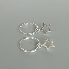 A PAIR of sterling silver hoops. Comes with a detachable tiny and delicate star charm. The charm is multipurpose and can be used with a neck or bracelet chain too. Dimension: Hoop- 12 x 1.2 mm Charm- 6 x 6 mm Weight: 0.97 gm Price listed is for a PAIR of hoops. These earrings are made of 925 hypoallergenic sterling silver and comes with a 925 stamp. Can be packaged in a gift box. I can include a personal message from you if needed You are welcome to contact me at... bhavnakwintra1956@gmail.com F Sterling Silver Star Charm Huggie Earrings, Sterling Silver Star Charm Cartilage Earrings, Silver Star-shaped Sterling Silver Hoop Earrings, Sterling Silver Star Cartilage Earrings With Star Charm, Sterling Silver Hoop Earrings With Star Charm For Gift, Silver Star-shaped Huggie Earrings For Gifts, Silver Star-shaped Minimalist Huggie Earrings, Small Hoop Sterling Silver Earrings With Star Charm, Silver Star Huggie Earrings For Everyday