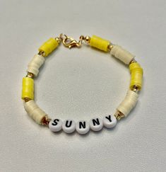 a yellow and white beaded bracelet with the word sunny written in small letters on it