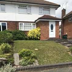 a house that has some bushes in front of it and stairs leading up to the door