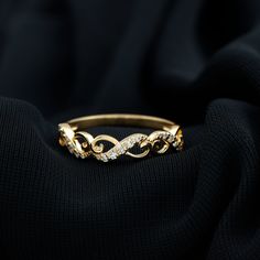 an elegant rose gold ring with diamonds on black fabric background, close - up photo