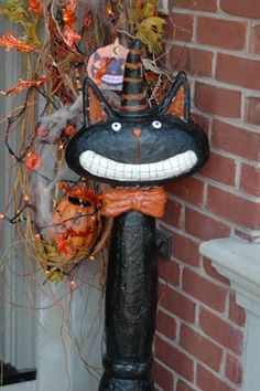 a halloween decoration with a black cat on it's head and an orange pumpkin